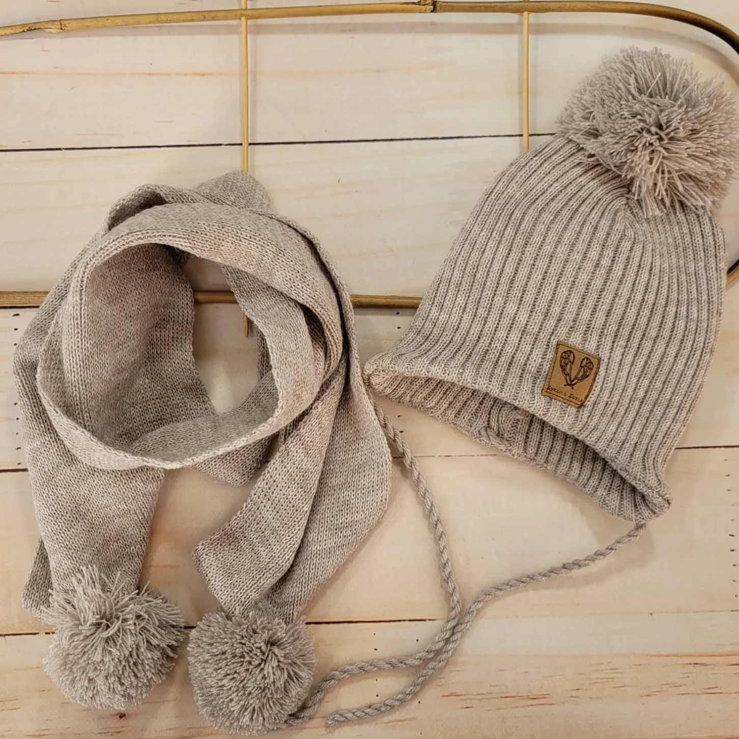 Komplet Czapka zimowa wiązana z pomponem + szalik z pomponami. Kolor piaskowy beż